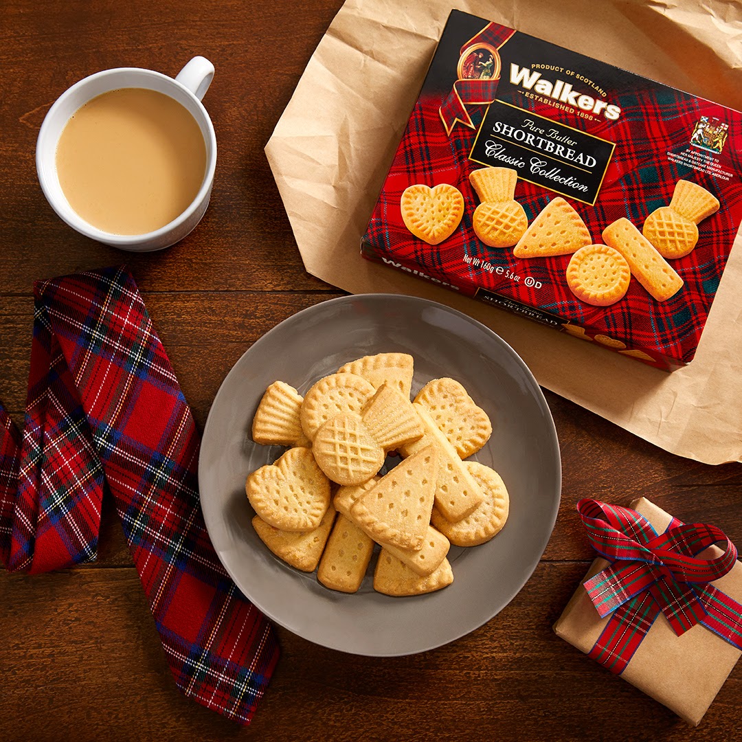 Tea and shortbread on a wooden table top along with a necktie and gift.